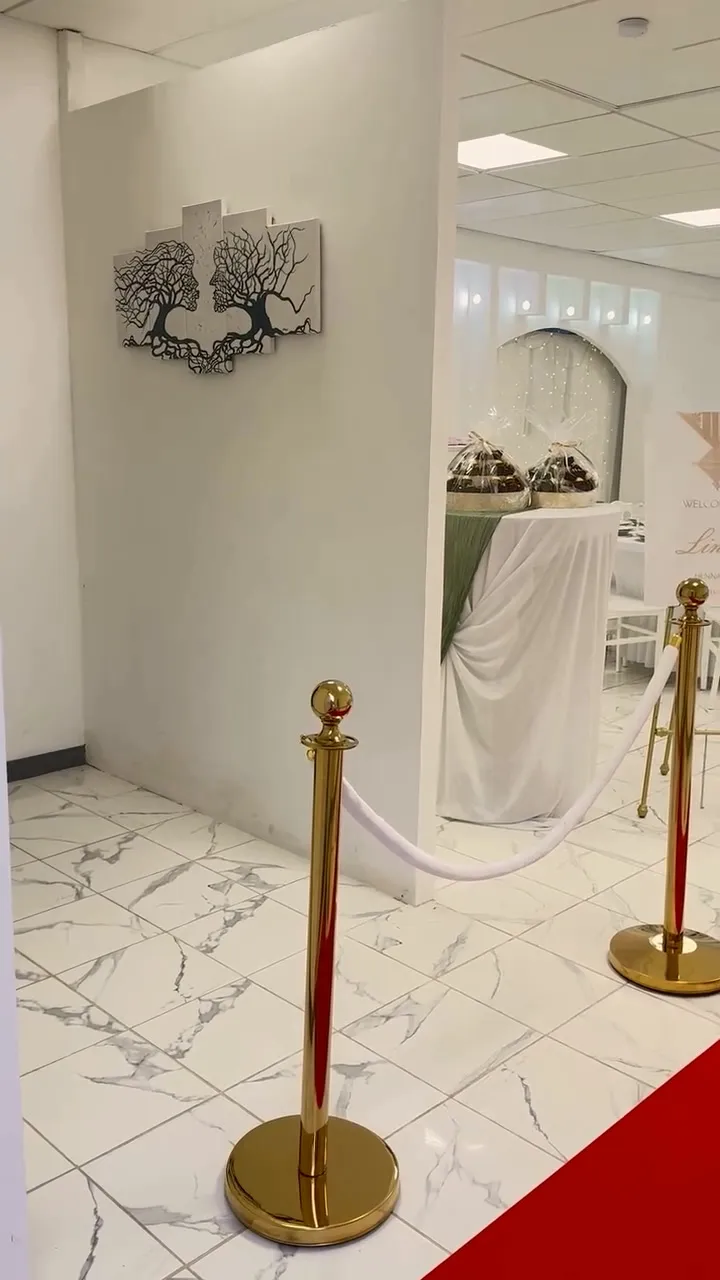 Table d'accueil drapée de blanc et de vert avec des paniers cadeaux pour les invités