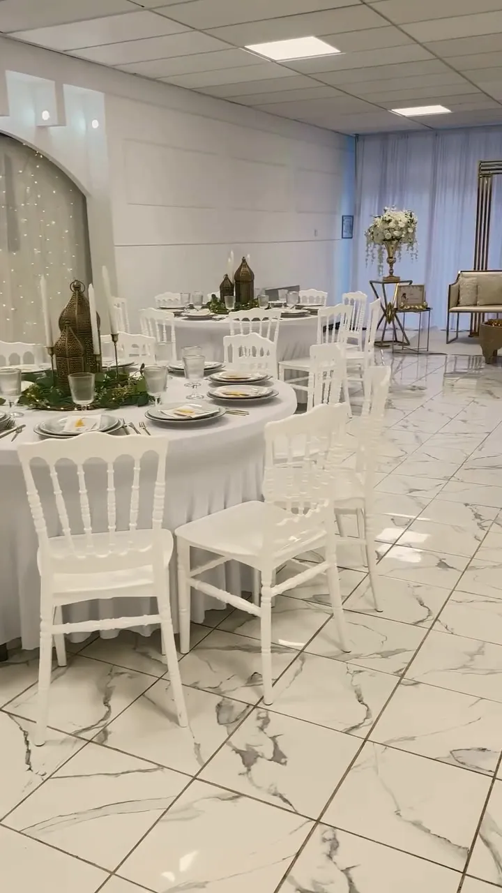 Vue de la salle avec ses tables rondes nappées de blanc, ses chaises Napoléon et son sol effet marbre